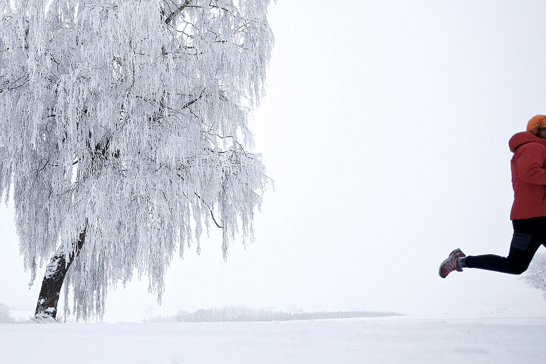 Mann joggt durch Winterlandschaft, Irsee, Bayern, Deutschland