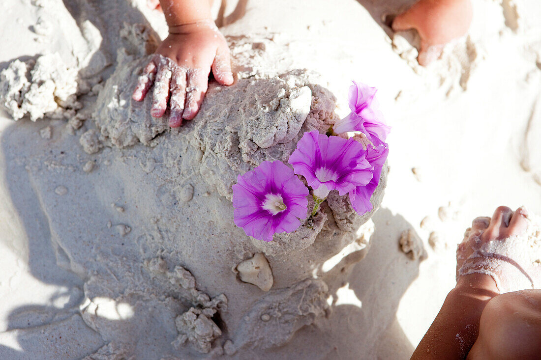 Mädchen spielen mit Blüten und Sand, Similan Inseln, Andamanensee, Thailand