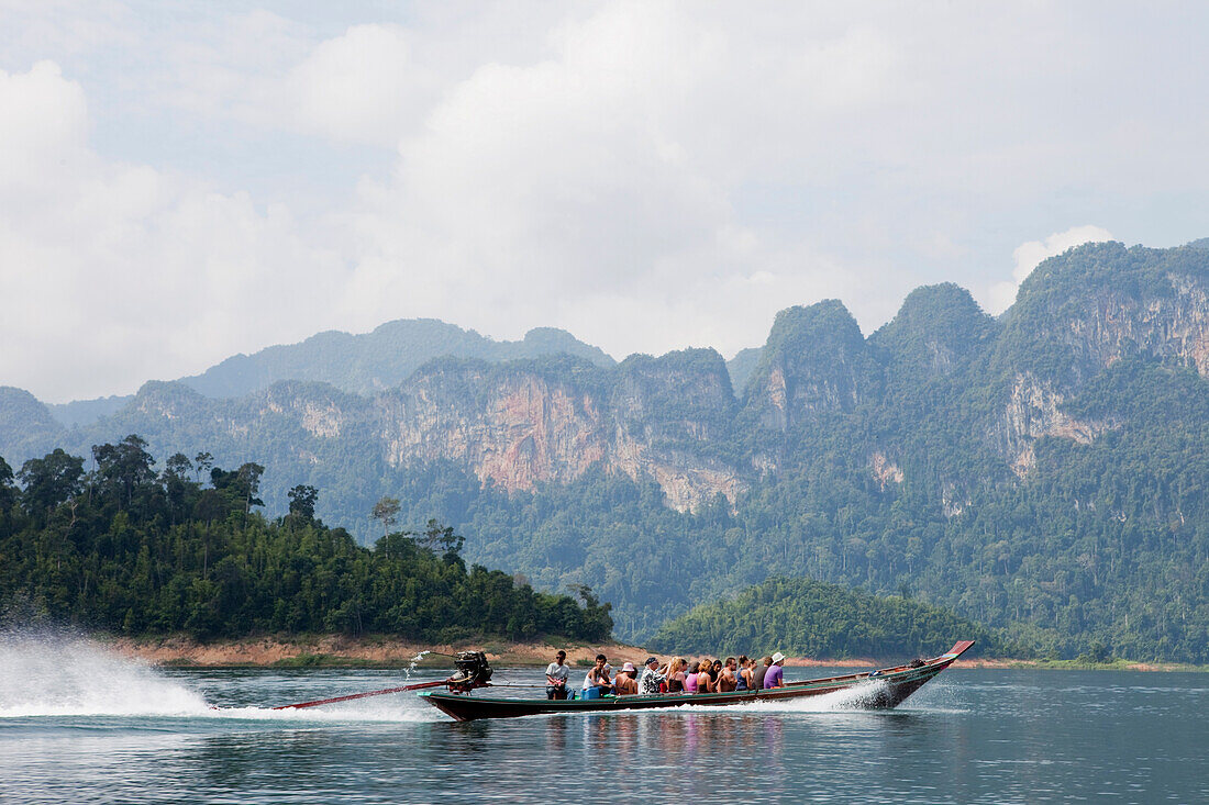 Longtailboot mit Touristen auf dem Stausee des Khao Sok Nationalparks, Khao Sok Nationalpark, Andamanensee, Thailand