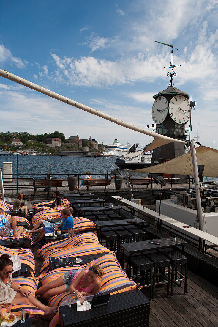 Junge Frauen chillen in den Sesseln einer Bar am Hafen, Oslo, Südnorwegen, Norwegen