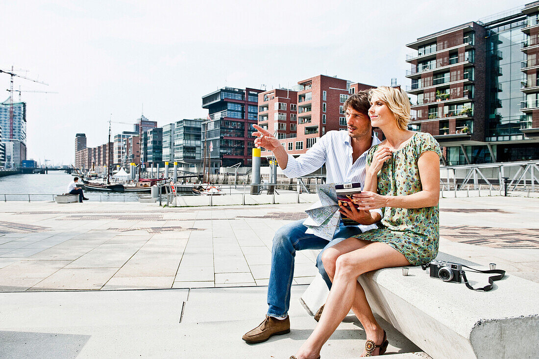 Couple reading a city map at Magellan-Terraces, HafenCity, Hamburg, Germany