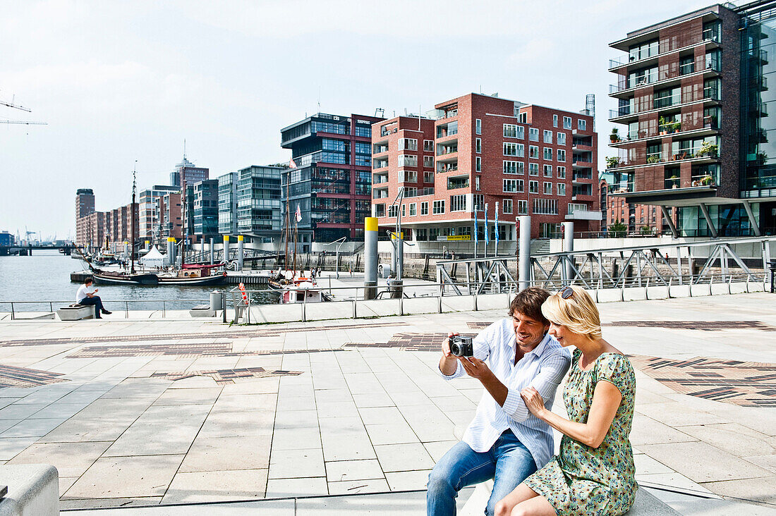 Couple with digital camera at Magellan-Terraces, HafenCity, Hamburg, Germany