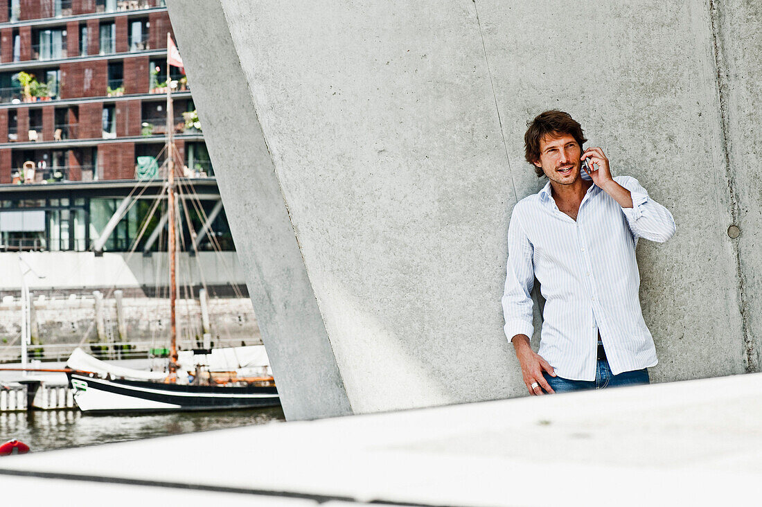 Mid adult man using a mobile phone, HafenCity, Hamburg, Germany