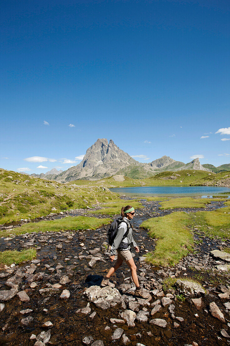 Frau wandert am Lac d'Ayous, Pic du Midi d'Ossau im Hintergrund, Ossautal, Französische Pyrenäen, Pyrénées-Atlantiques, Aquitaine, Frankreich