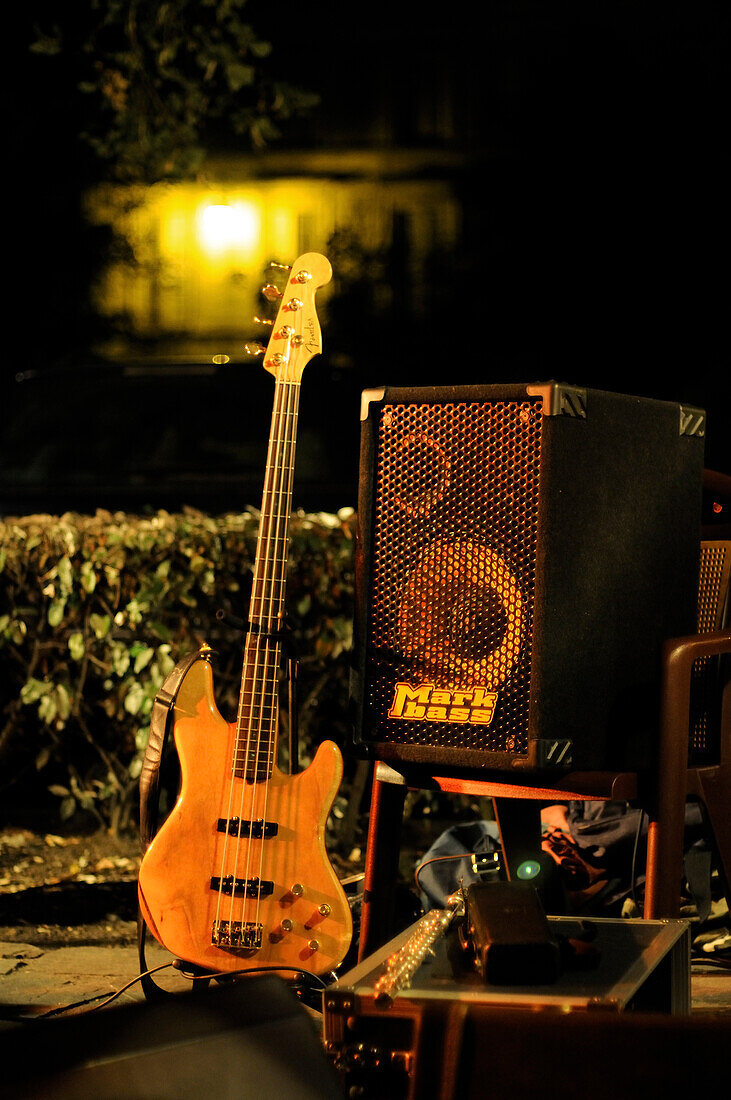 Bass guitar and amplifier set up outdoors for nighttime performance
