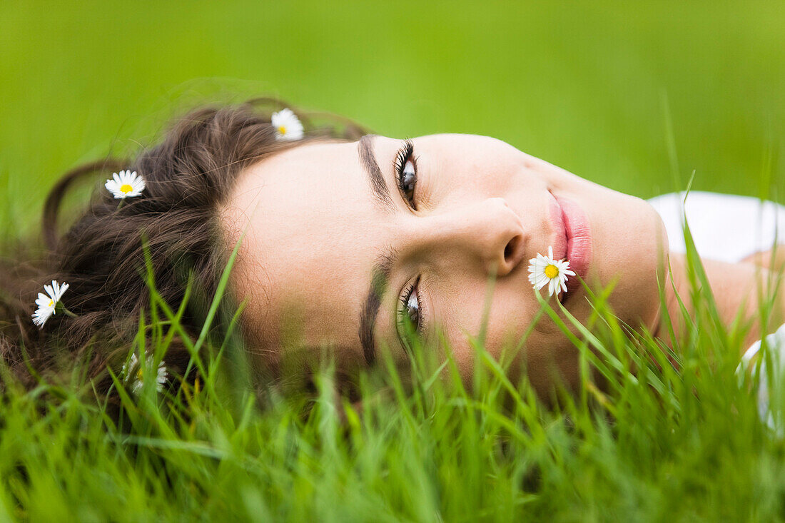 Young woman lying in grass – License image – 70364607 lookphotos