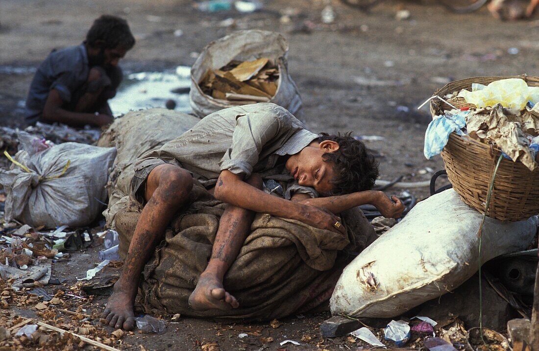 Inde, Maharastra, Mumbai, Scavenger stoned on glue sleeping on a garbage bag