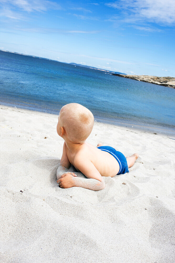 Young Boy Sitting on Sandy West Coast Beach, Sweden