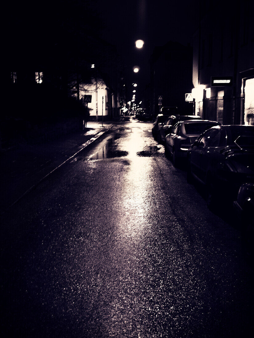 Rain Puddles and Parked Cars on Narrow Street at Night, Stockholm, Sweden