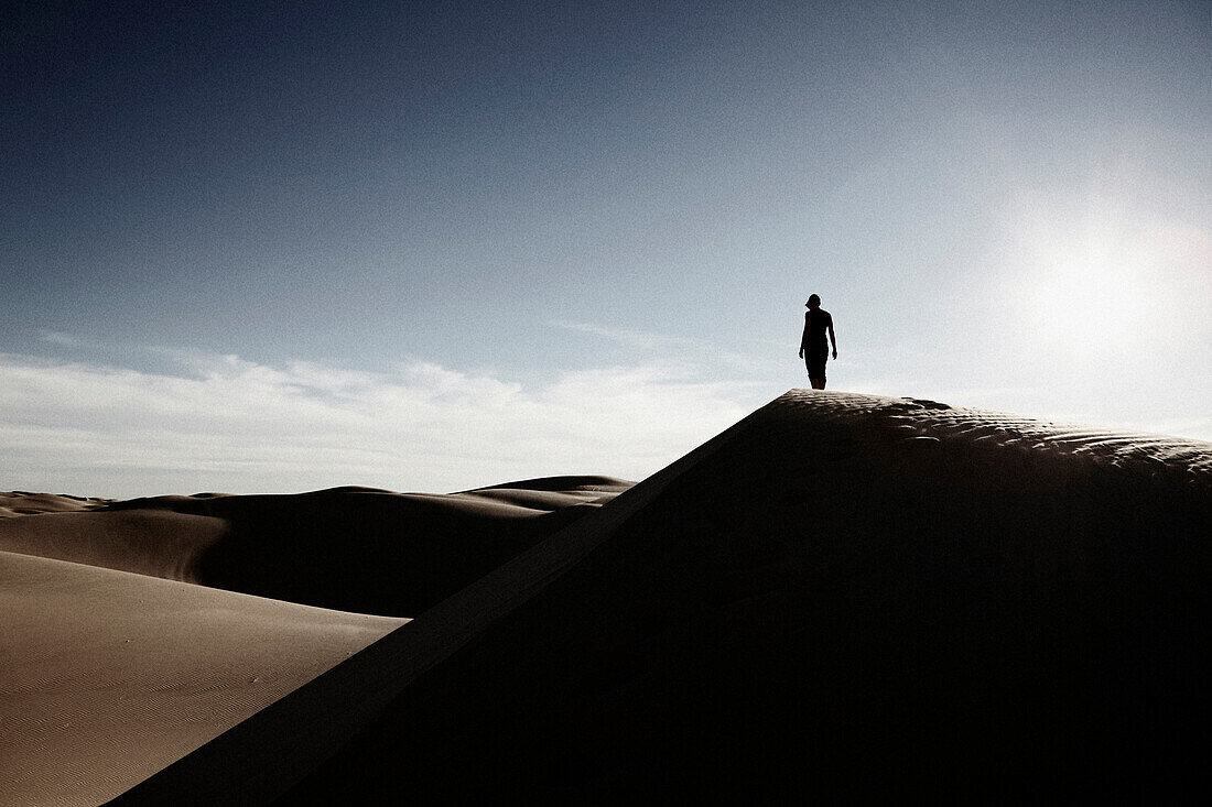 Woman Standing at Top of Desert Sand Dune, California, USA