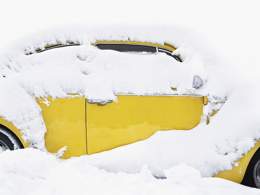 Yellow Car Covered in Snow