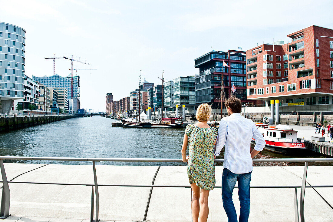 Couple looking over harbor basin, Magellan-Terraces, HafenCity, Hamburg, Germany