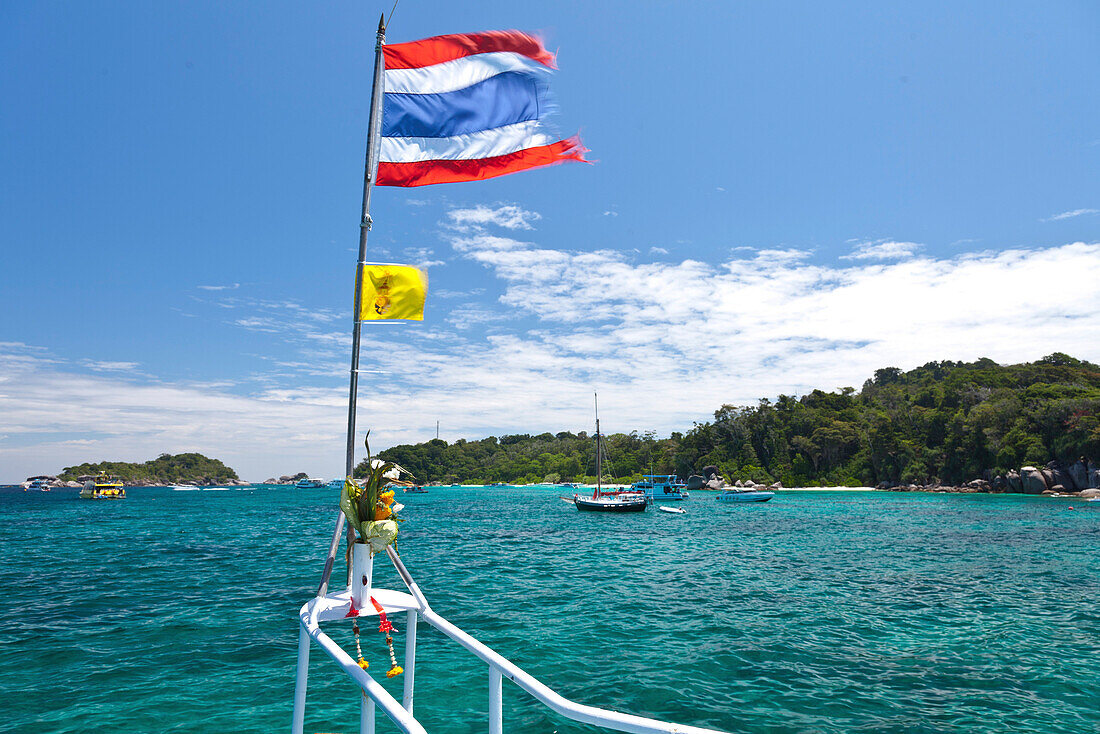 Thailändische Fahne im Wind und Boote in einer Bucht, Similan Inseln, Andamanensee, Indischer Ozean, Khao Lak, Thailand, Asien