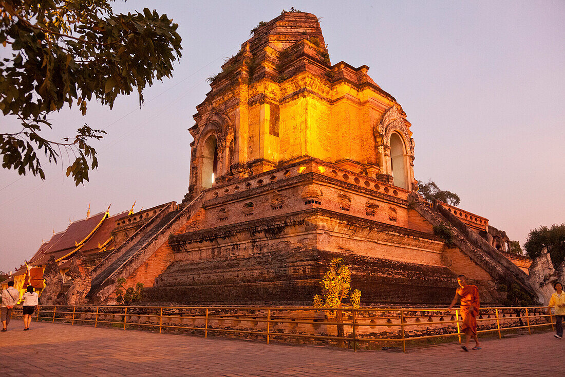 Monk in front of the great stupa of Wat Chedi Luang in the evening light, Chiang Mai, Thailand, Asia