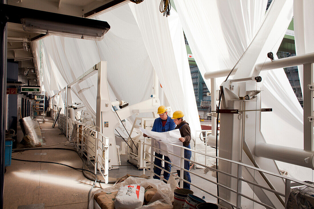 Monteure mit Kontruktionsplan, Kreuzfahrtschiff im Bau im Trockendock, Meyer Werft, Papenburg, Niedersachsen, Deutschland