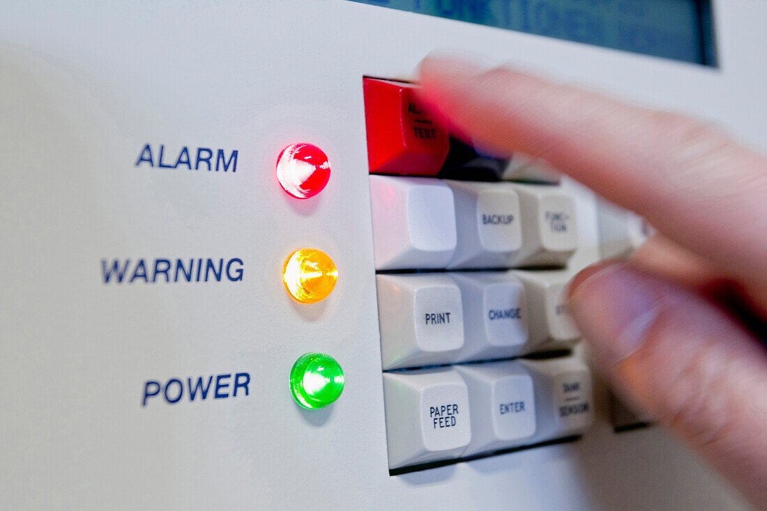 Hand pushing button on alarm system, Germany