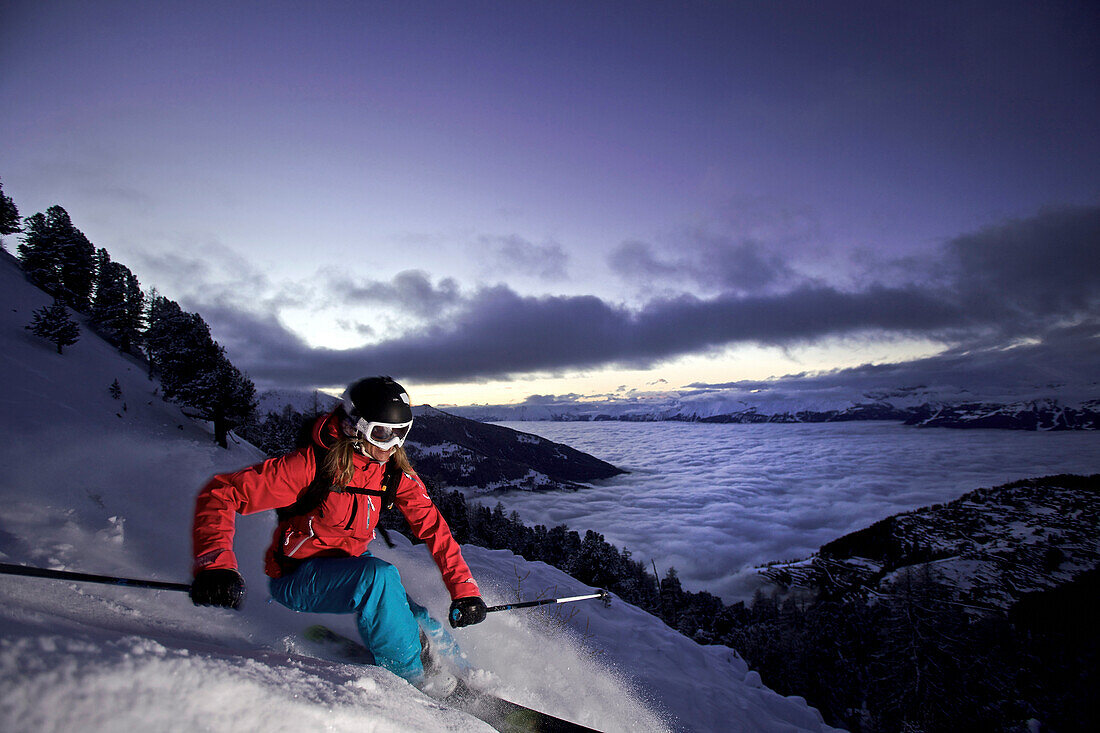 Female skier in deep snow at twilight, Chandolin, Anniviers, Valais, Switzerland