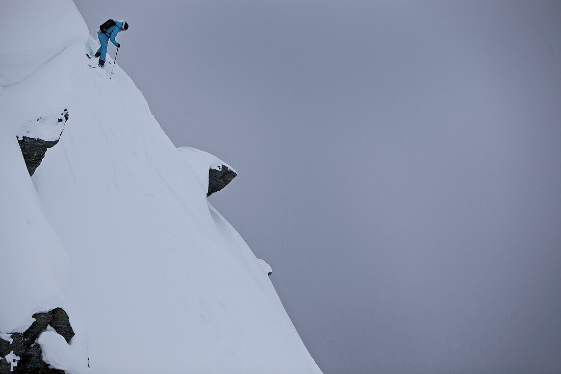 Skifahrerin steht an einem steilen Hang, Chandolin, Anniviers, Wallis, Schweiz