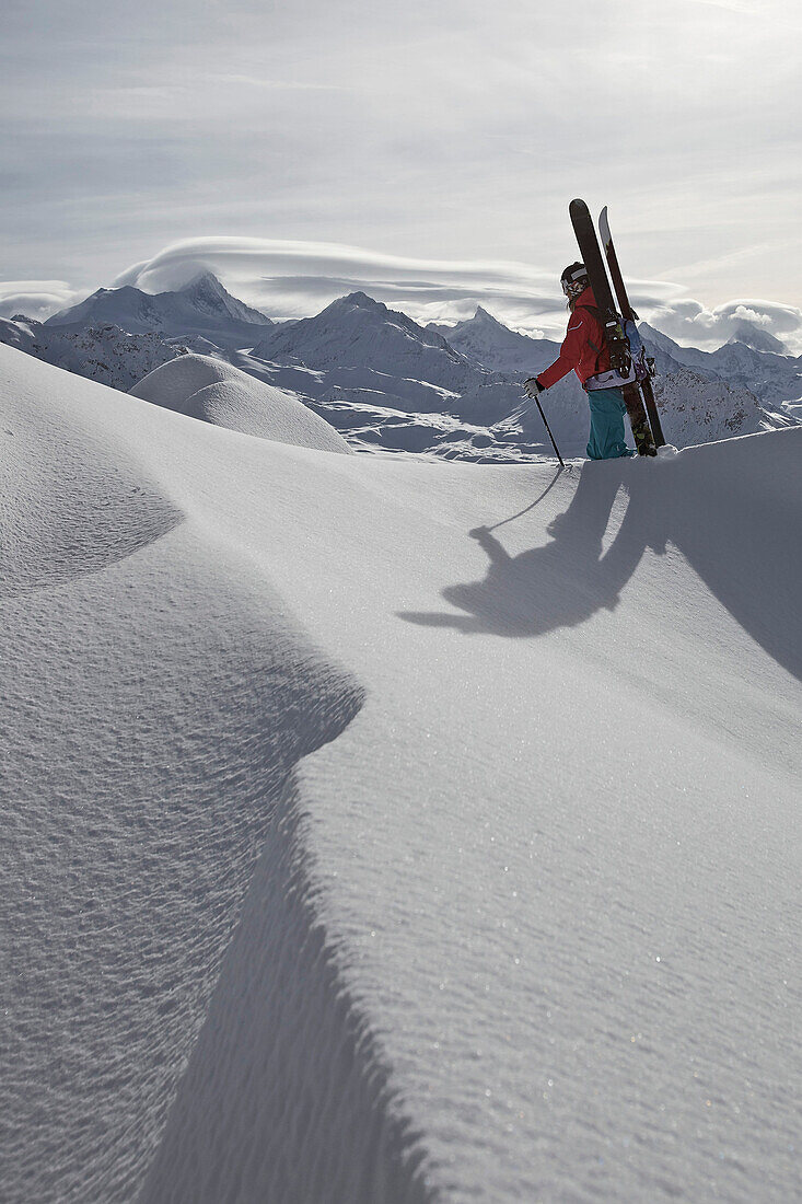 Female skier ascending through deep snow, Chandolin, Anniviers, Valais, Switzerland