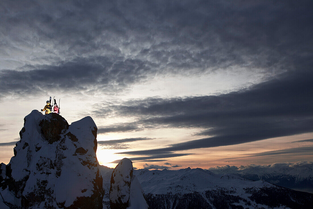 Two skiers on mountain top in twilight, Chandolin, Anniviers, Valais, Switzerland