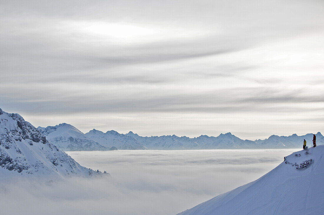 Two people enjoying mountain panorama over clouds, Hahnenkamm, Kitzbuehel, Tyrol, Austria