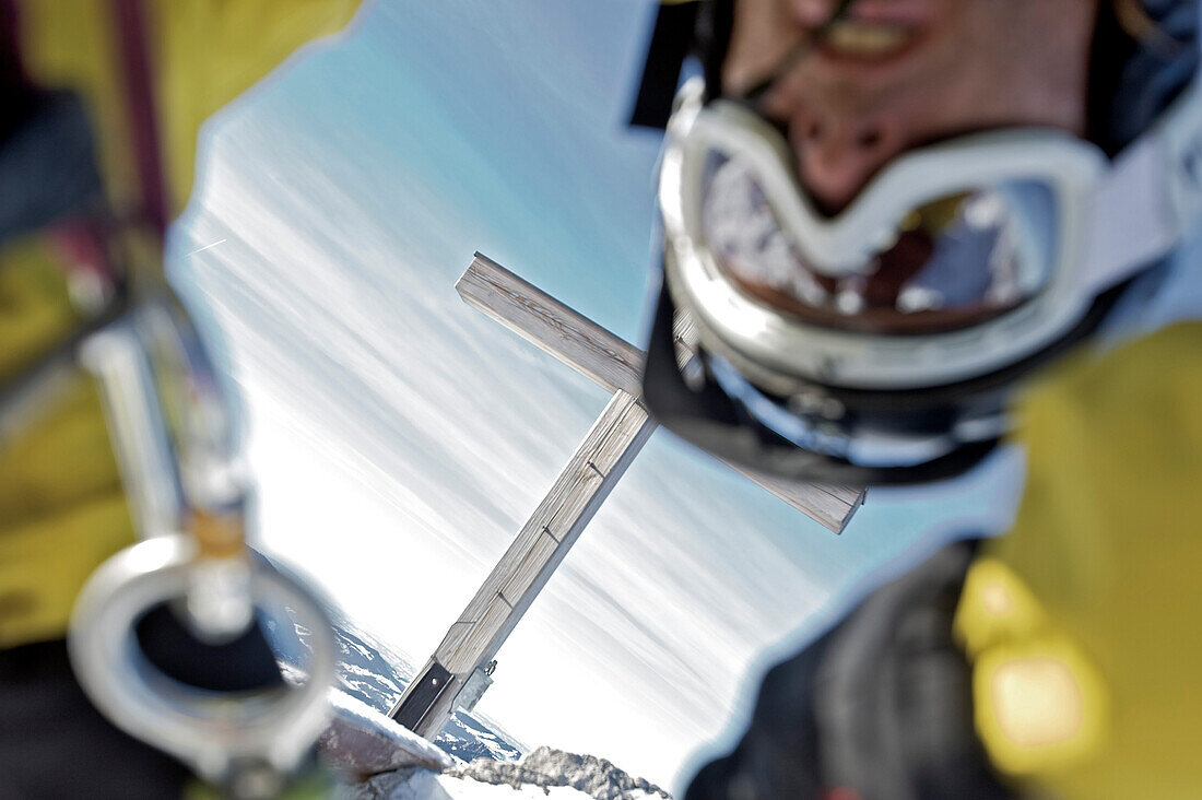 Snowboarder rappeling, summit cross in background, Oberjoch, Bad Hindelang, Bavaria, Germany