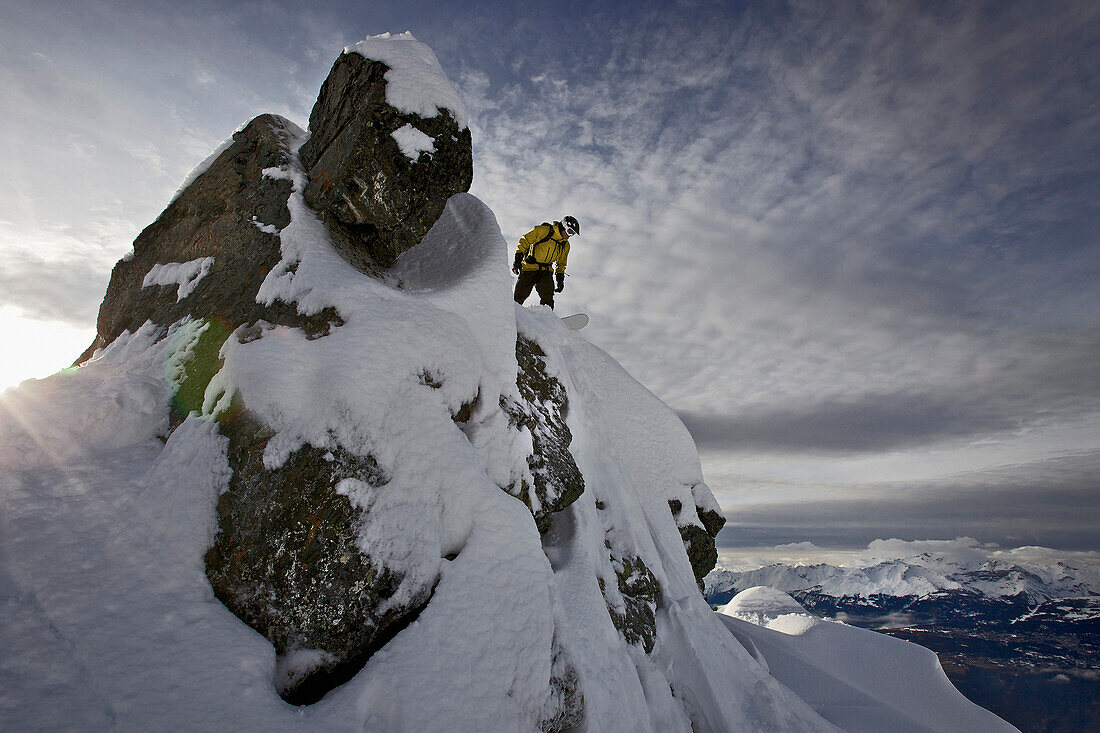Snowboarder standing on a mountain, Chandolin, Anniviers, Valais, Switzerland