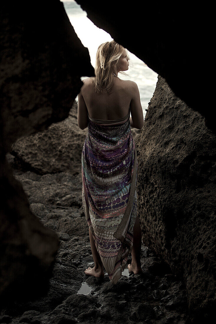 Junge Frau auf einem Felsen am Meer, Fuerteventura, Spanien