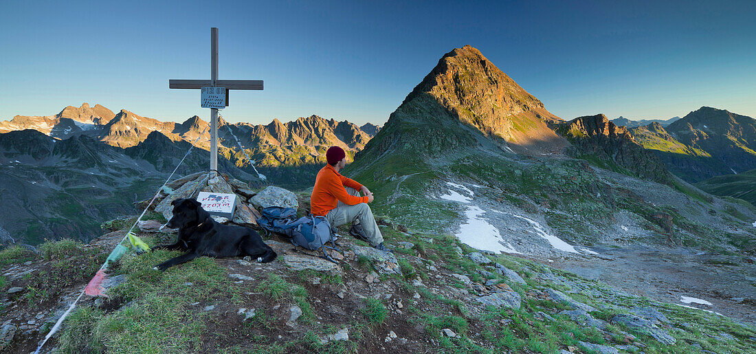 Eine Person mit einem Hund am Gipfelkreuz, Hohes Rad, Radsattel, Bieltal, Vorarlberg, Tirol, Österreich