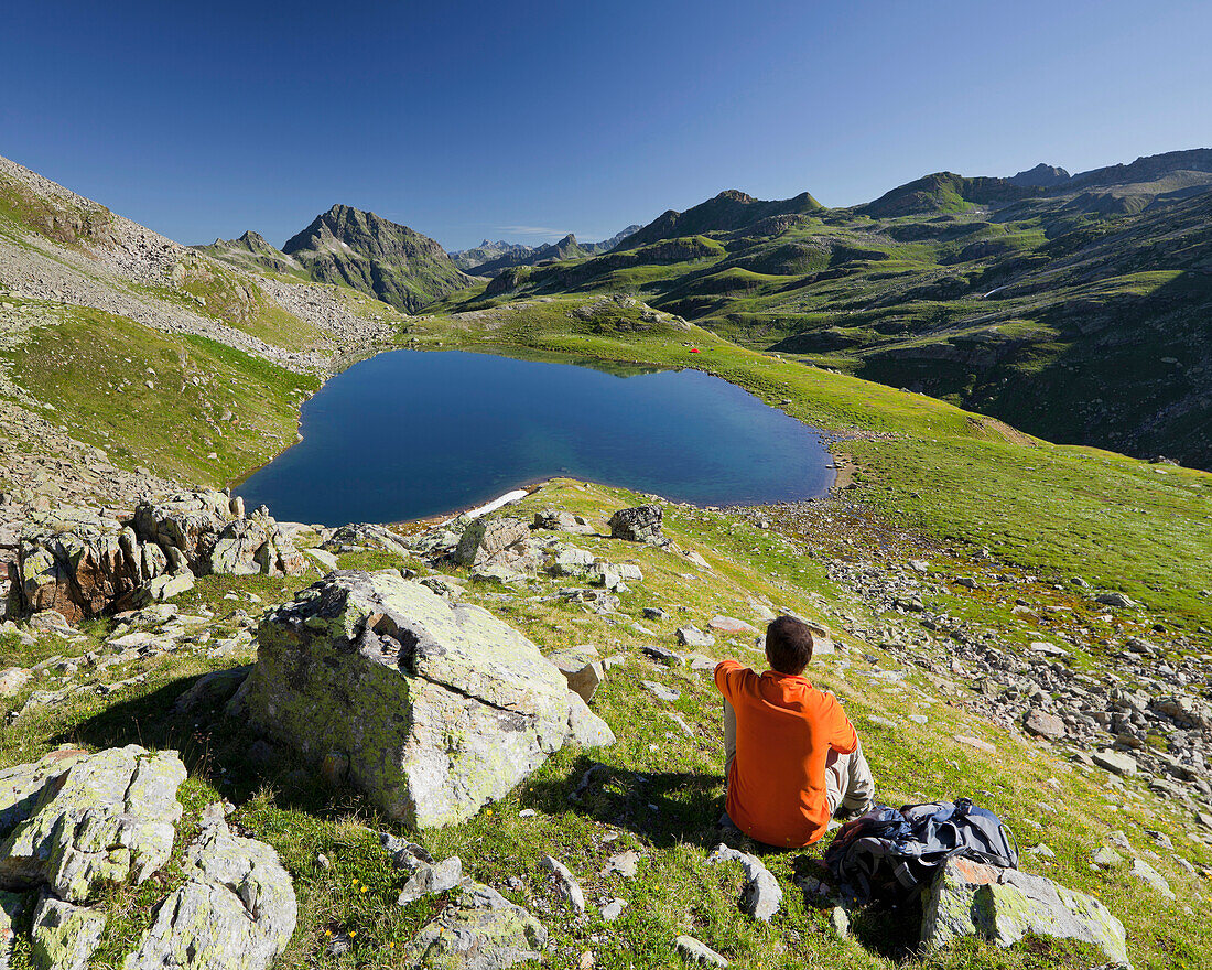 Person admiring the view at lake Radsee, Vallula, Bieltal, Tyrol, Austria