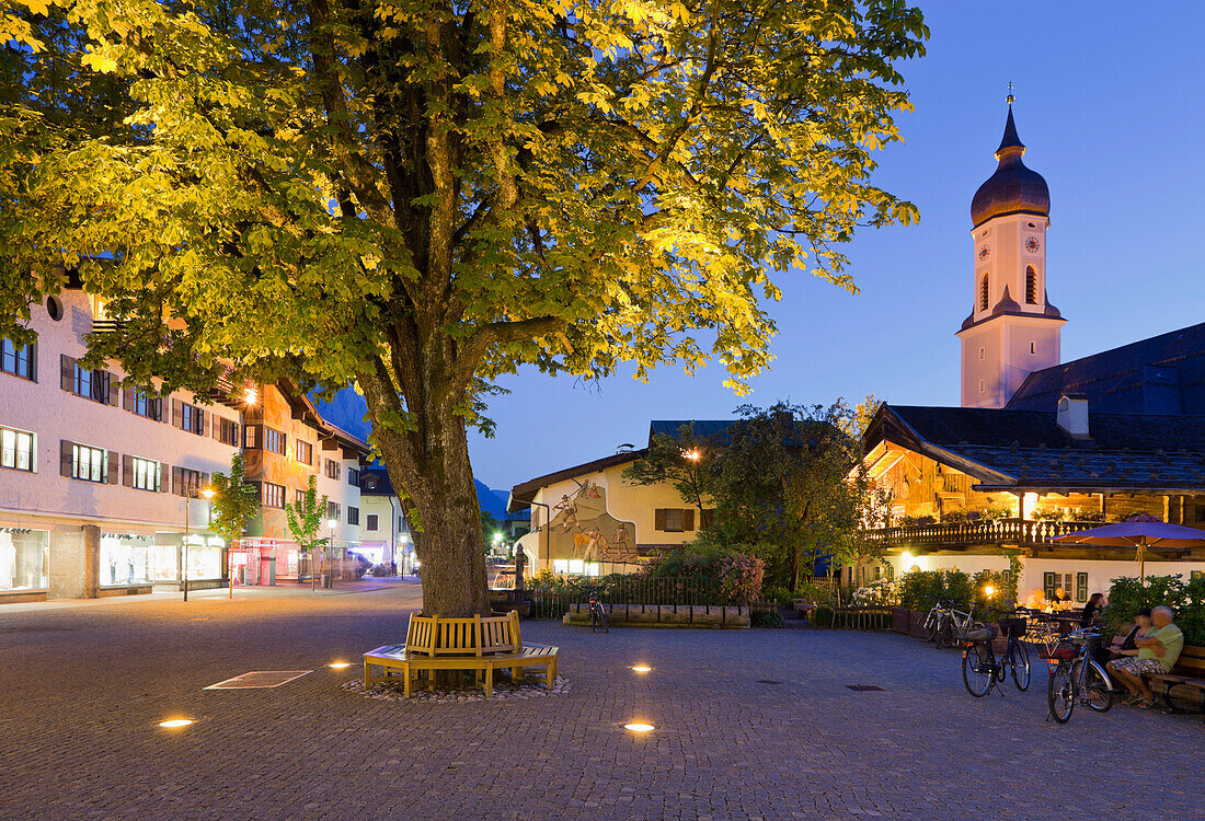 Baum und beleuchtete Kirche in Garmisch-Partenkirchen, Bayern, Deutschland