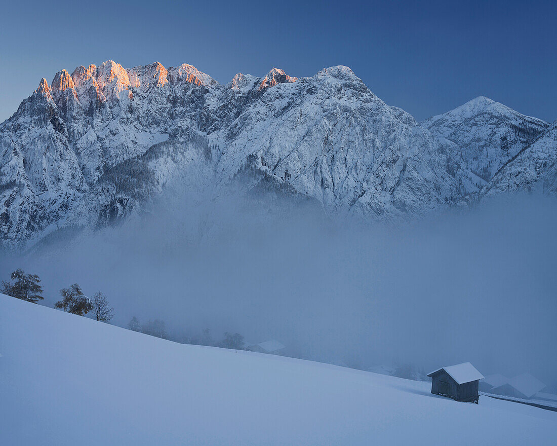 Blick auf Hütte im Schnee, Pustertal, Bannberg und Spitzkofel bei Sonnenuntergang, Lienzer Dolomiten, Tirol, Österreich, Europa