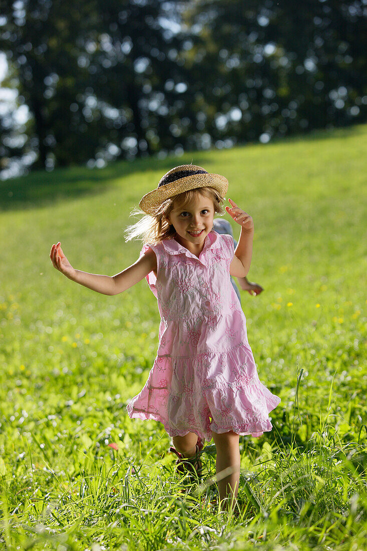 Mädchen (5 Jahre) läuft über Wiese, Starnberger See, Bayern, Deutschland