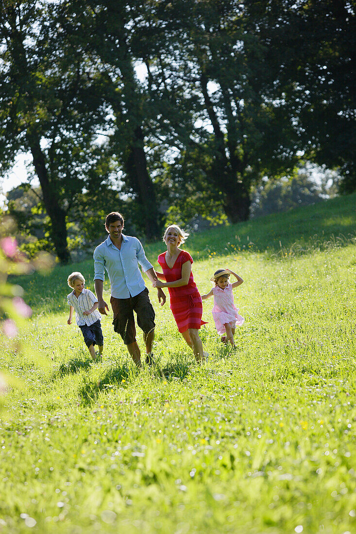 Family walking over meadow, Lake Starnberg, Bavaria, Germany