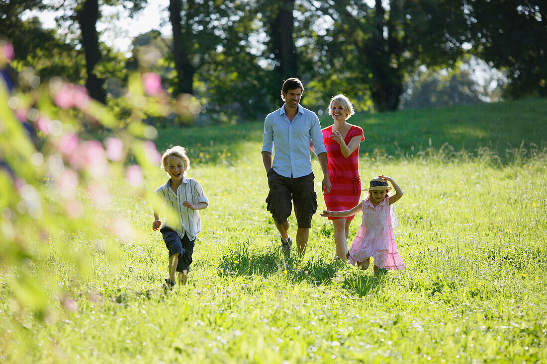 Familie läuft über Wiese, Starnberger See, Bayern, Deutschland