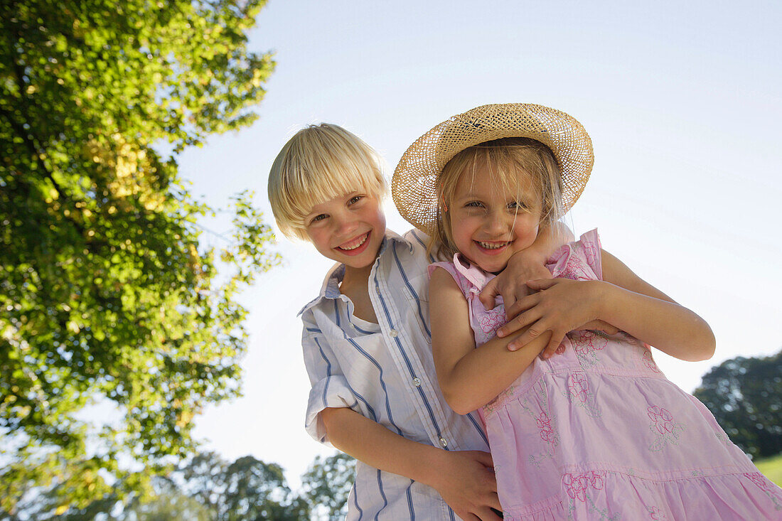 Sibling, 5 and 7 years, smiling at camera, Lake Starnberg, Bavaria, Germany