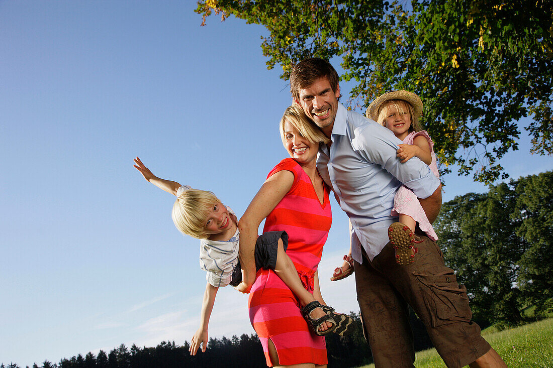 Eltern tragen Kinder huckepack, Starnberger See, Bayern, Deutschland