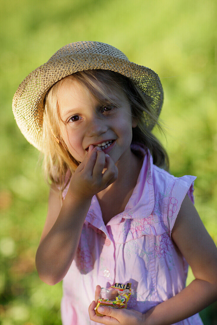 Girl (5 years) eating bummi bears, Lake Starnberg, Bavaria, Germany