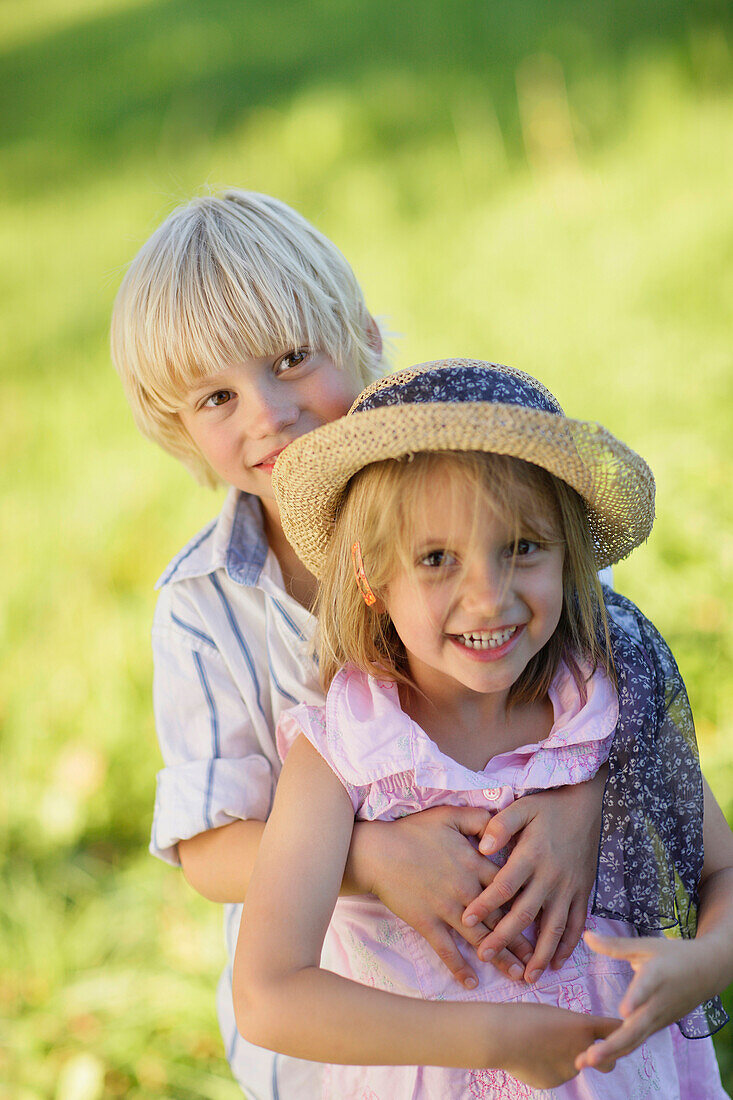 Sibling (5 and 7 years) smiling at camera, Lake Starnberg, Bavaria, Germany