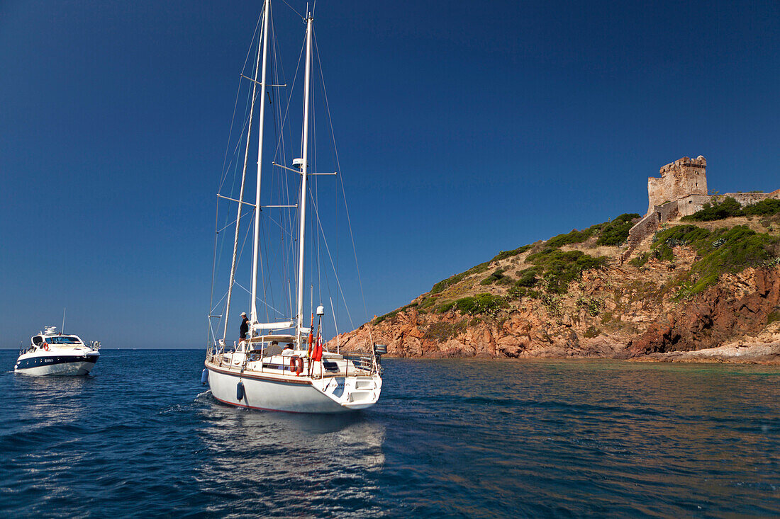 Boat anchored by a Genoese Tower, village of Girolata, Corsica, France