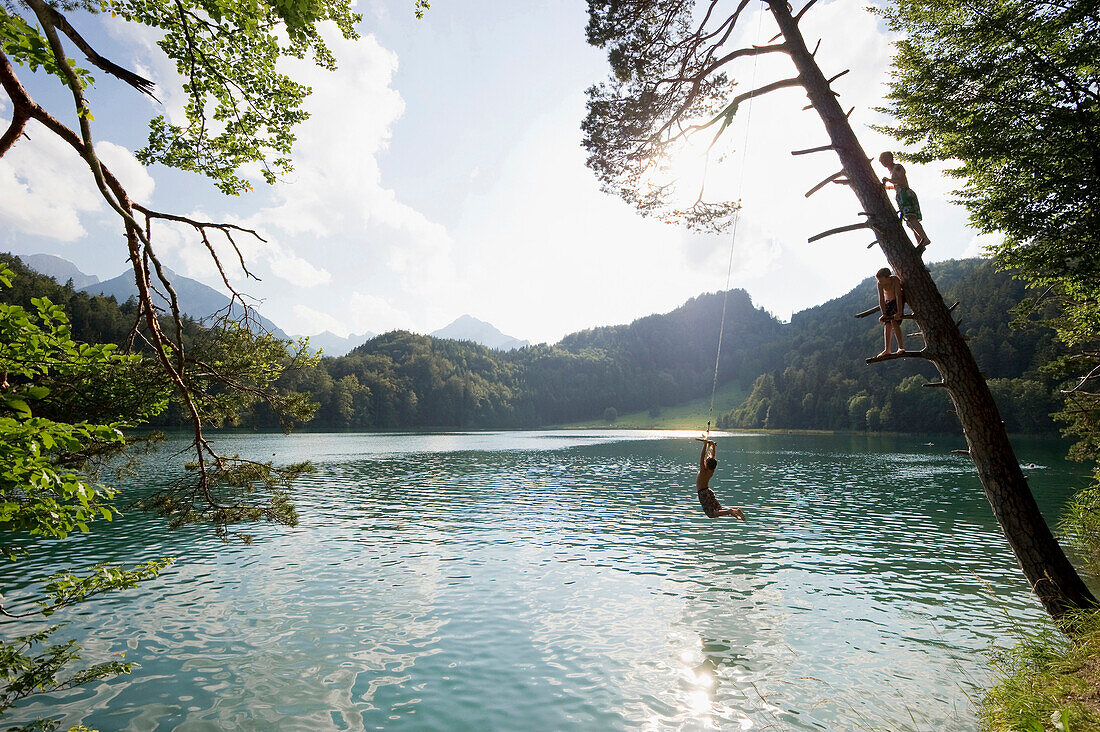 Three children at lake Alatsee, near Fuessen, Allgaeu, Bavaria, Germany