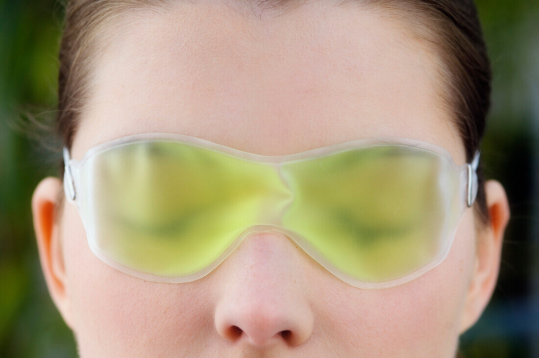Woman with a gel eye mask, close up (studio)