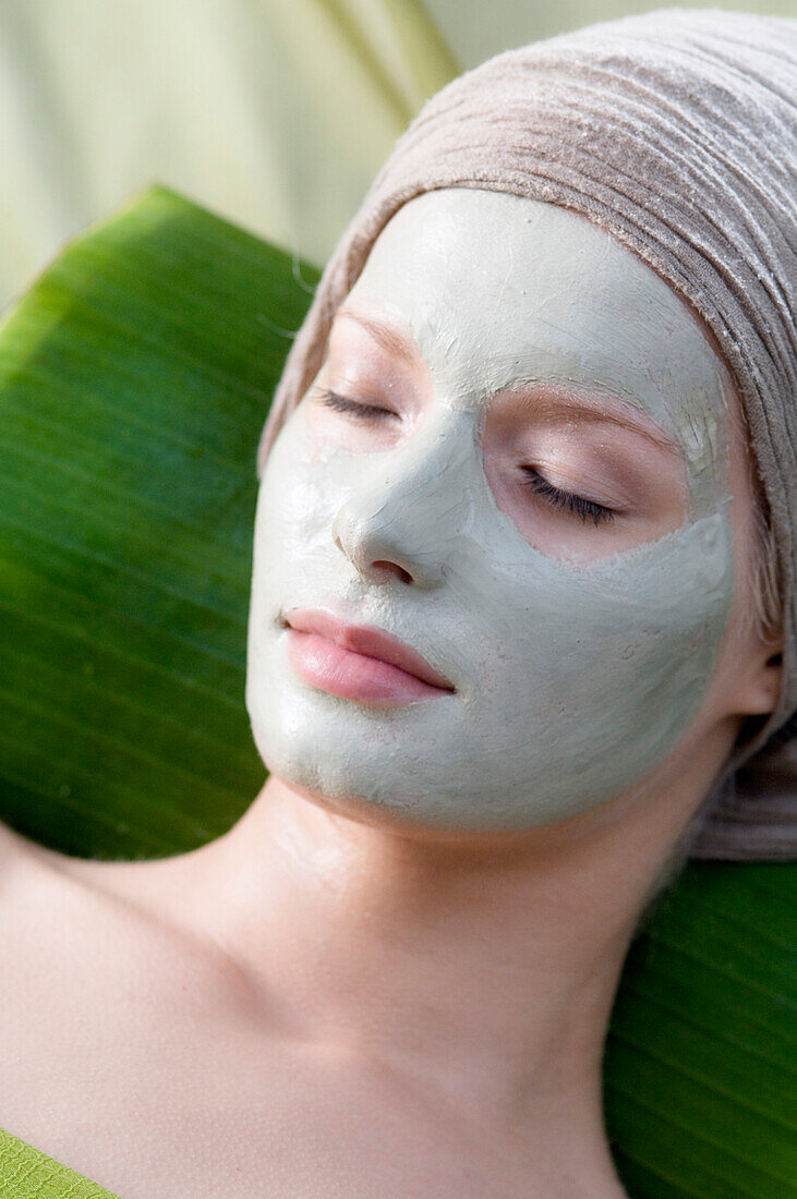 Young Woman face with beauty mask, shut eyes