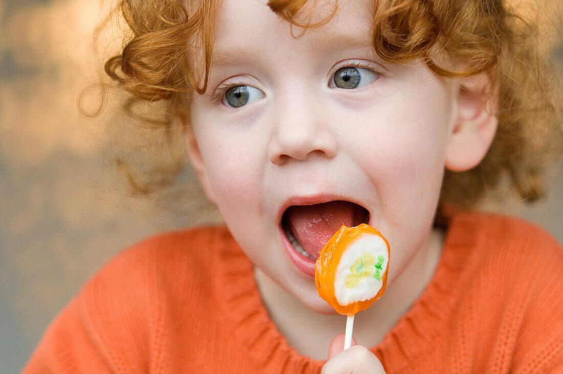 Portrait of a little girl eating lollipop