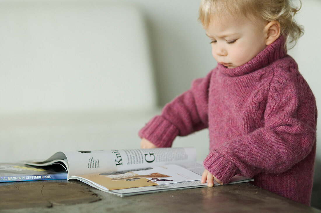 Little boy reading a magazine