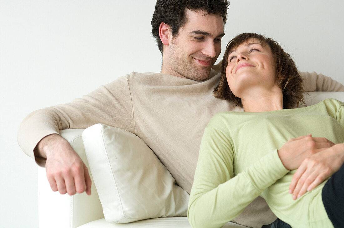 Couple lying on a sofa, looking at each other