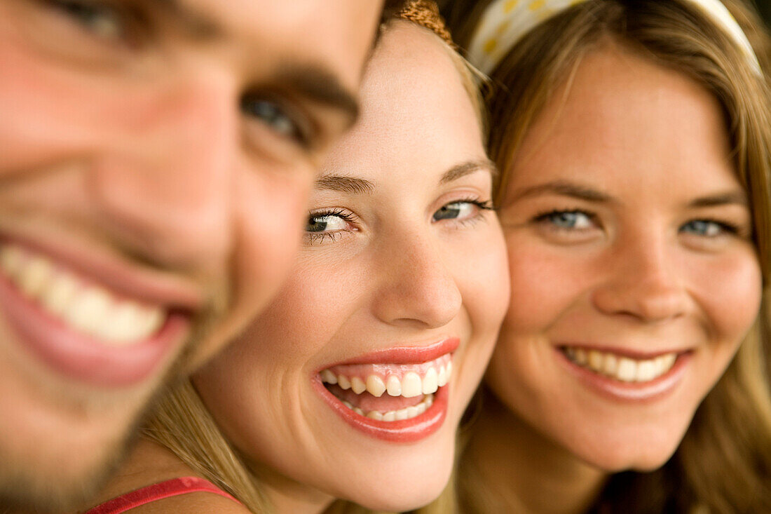 2 young women and a man smiling for the camera