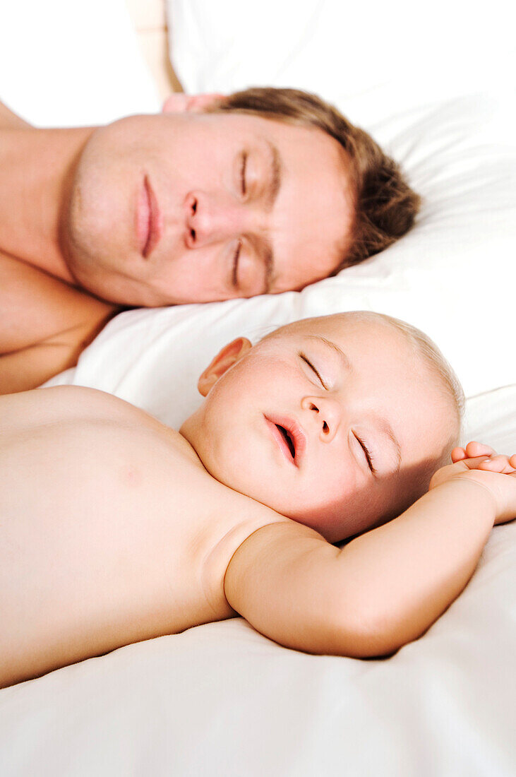 Portrait father and baby sleeping, indoors