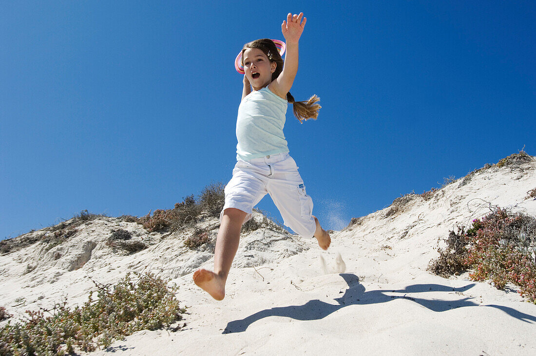 Little girl running on the beach, outdoors