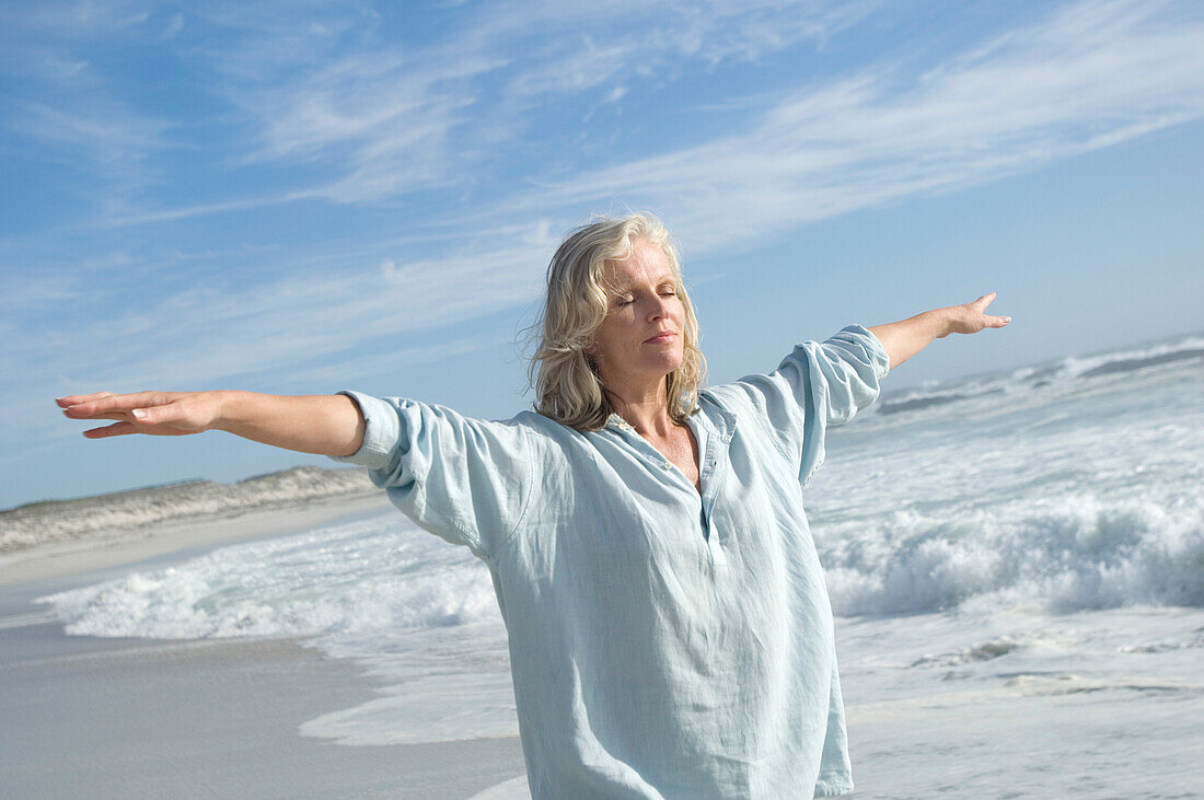 Woman in yoga attitude on the beach, outdoors